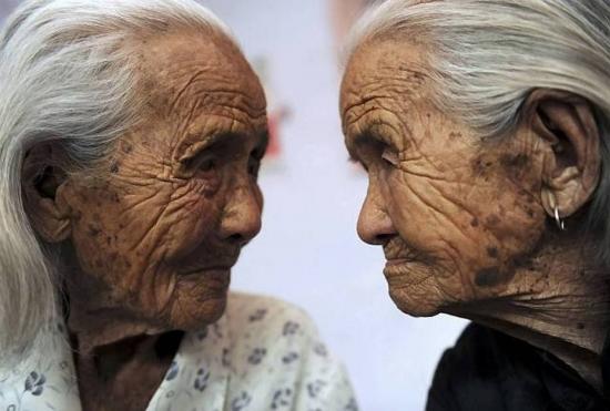 O aumento da expectativa de vida motivou o investimento em graduação voltada para os idosos. Na imagem, as gêmeas chinesas Cao Xiaoqiao e Cao Daqiao, aos 104 anos, em 2009.
